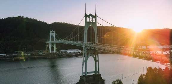 bridge over river at sunset